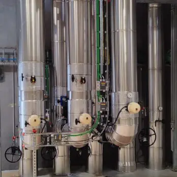 Industrielle Rohrleitungssysteme im Fernwärmepumpenhaus mit Flanschen und PUR-Isolierung