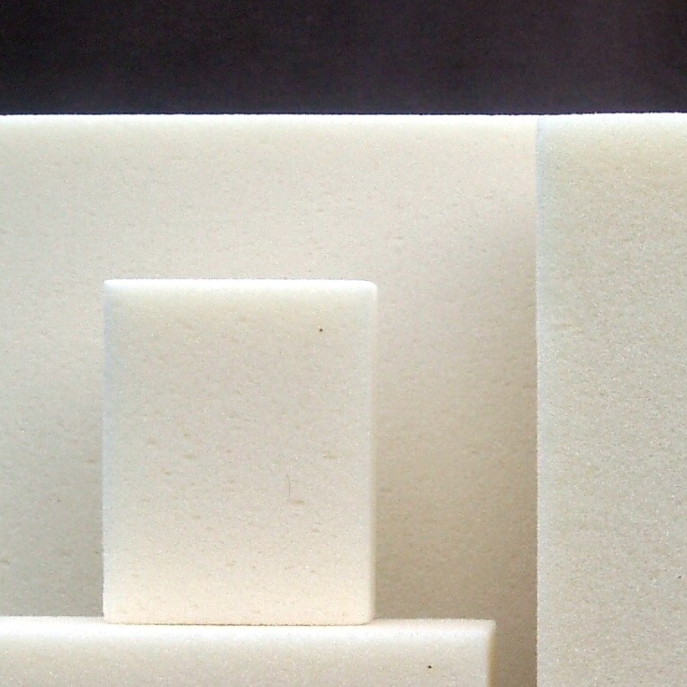 Rechteckige PUR-Schaumblöcke in verschiedenen Größen, gruppiert vor dunklem Hintergrund platziert.
